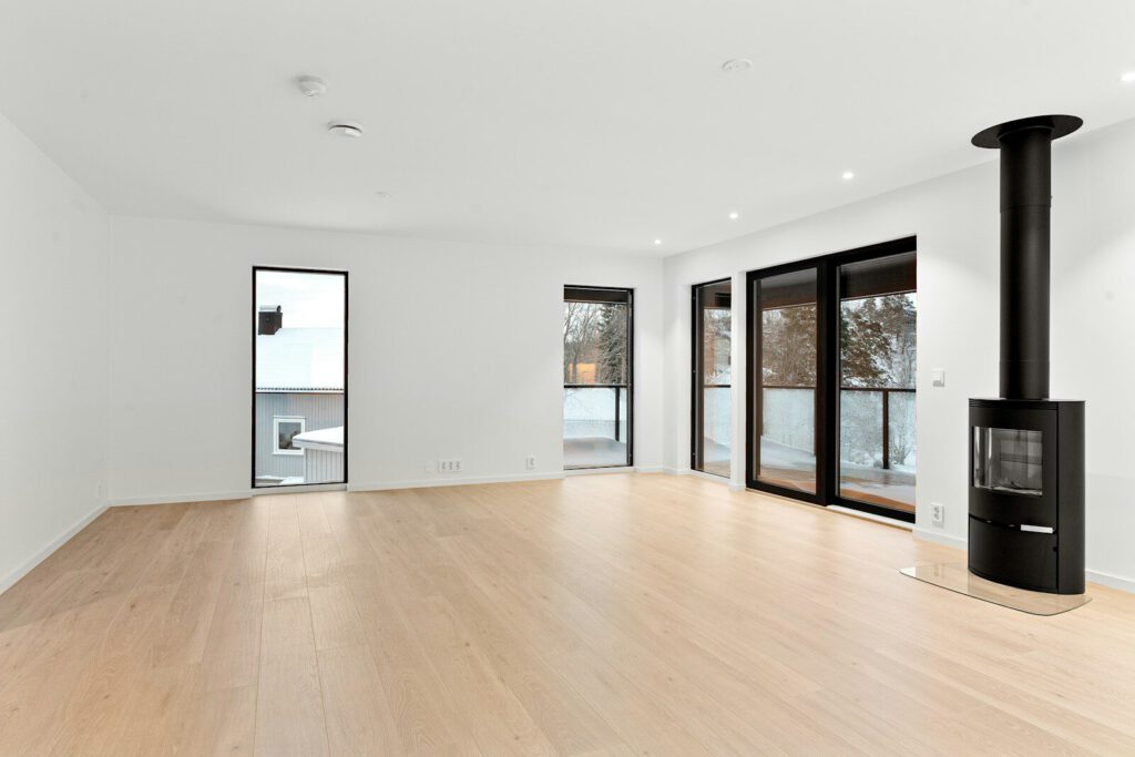 An empty room with a wood floor and a fire place