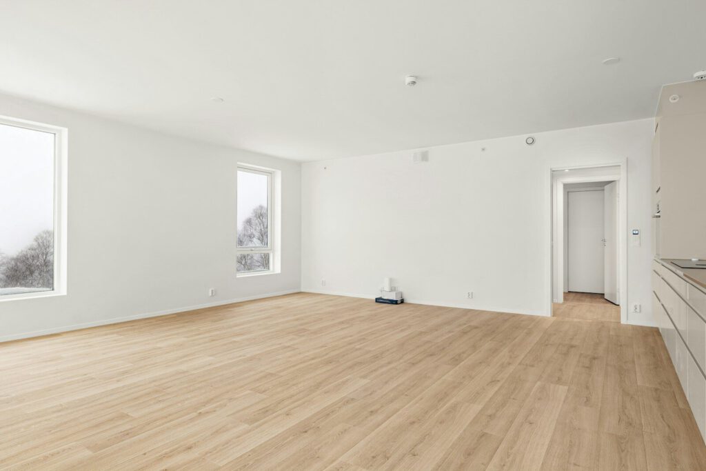 An empty room with a wood floor and white walls